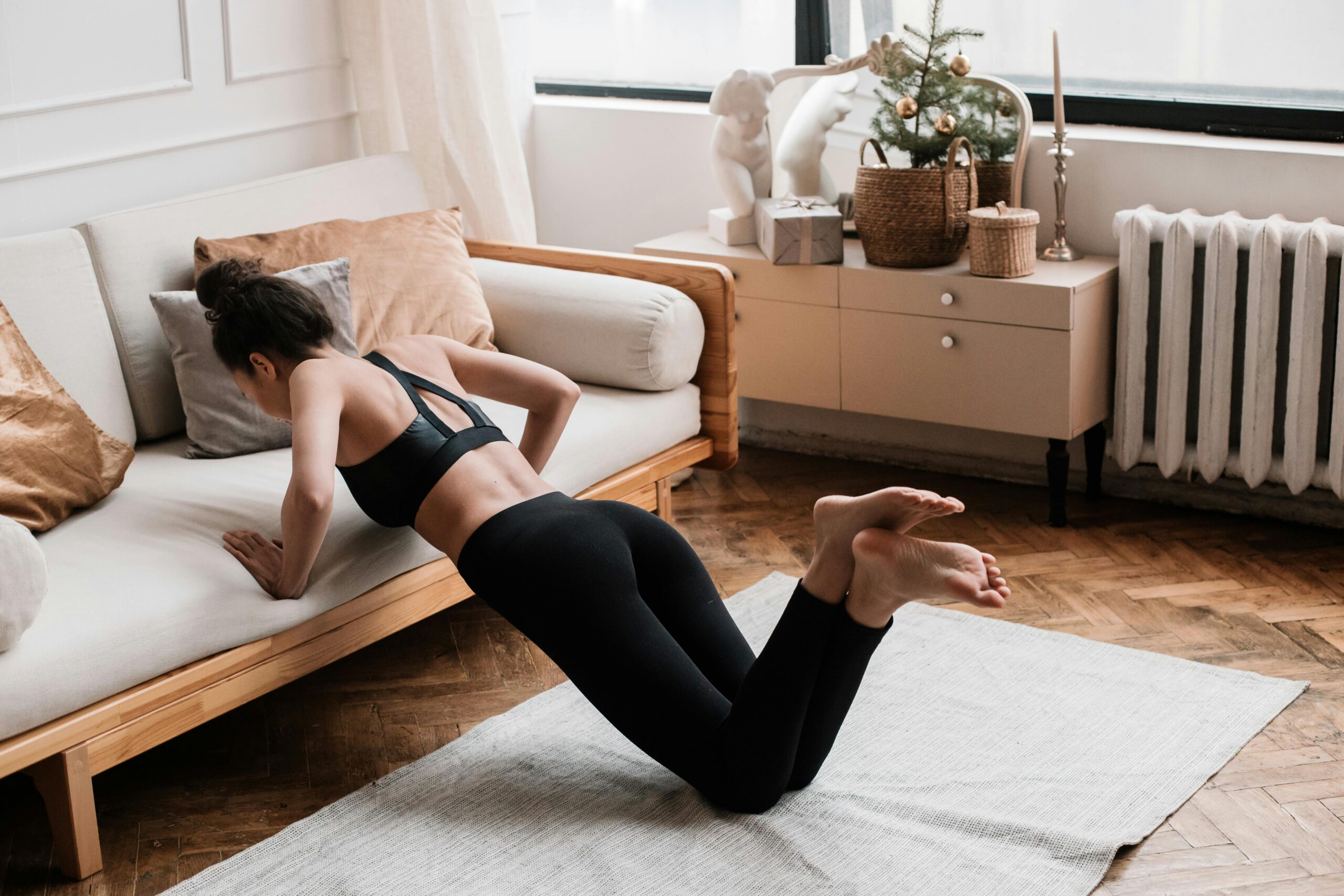 A woman stretches on a mat in a stylish living room, promoting a healthy lifestyle.